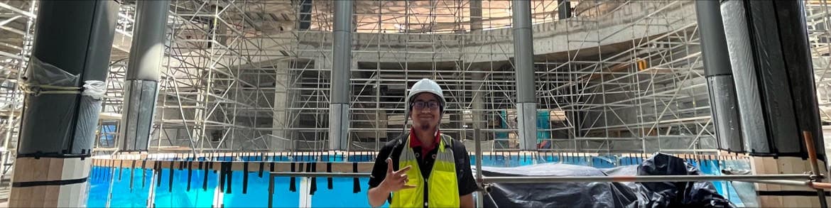 Izzat wearing a hard hat and safety vest at the TRX Mall construction site